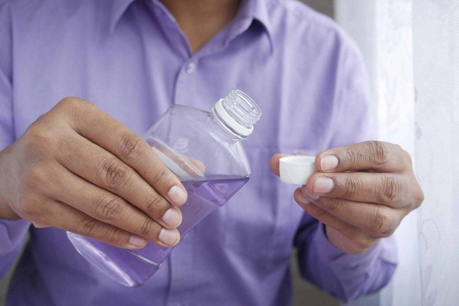 Man holding ultra klean mouthwash preparing for test